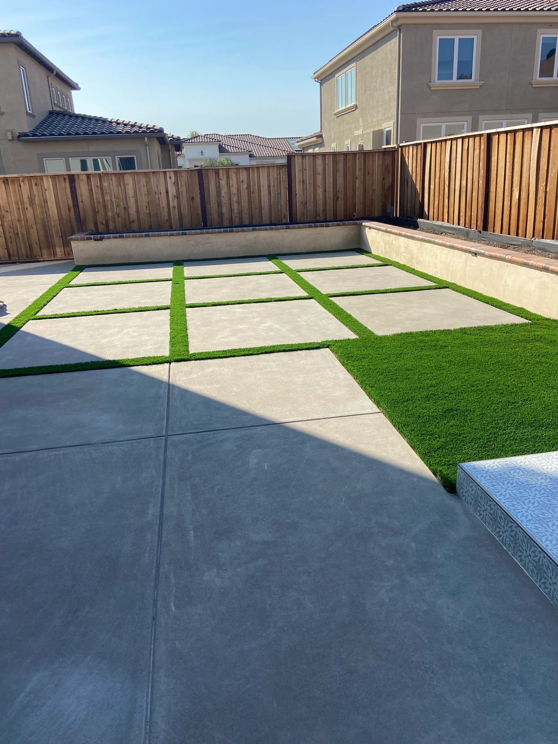 Square pavers and artificial grass yard