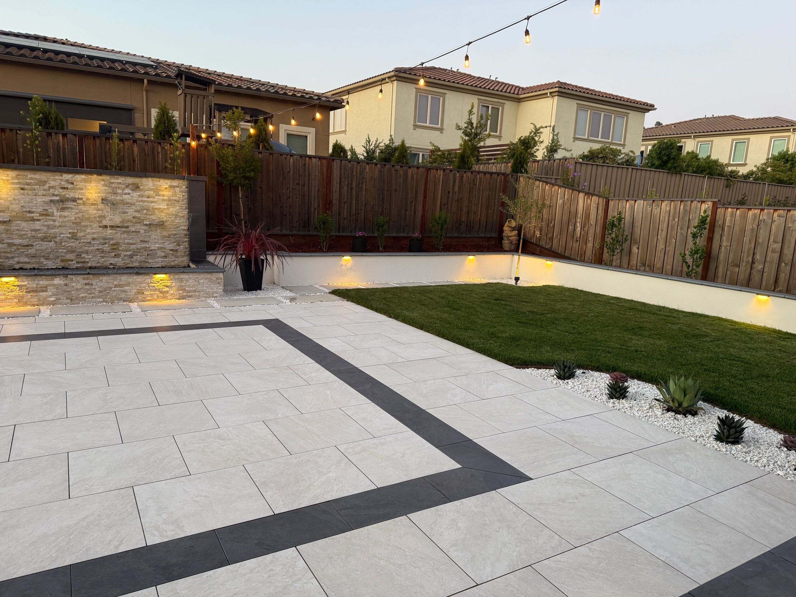 Landscaped yard with stone tiles and grass