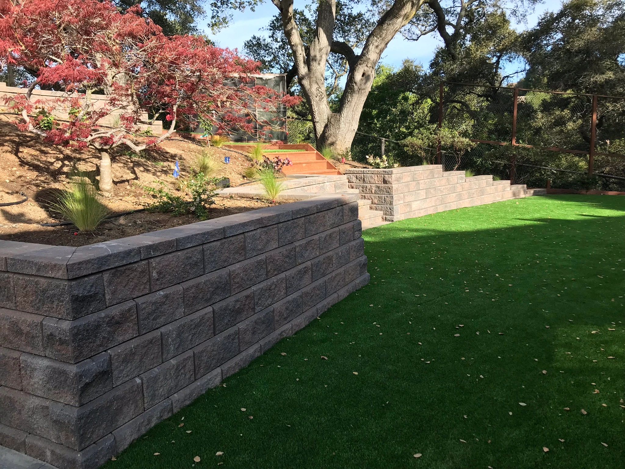 Stone retaining wall with green lawn