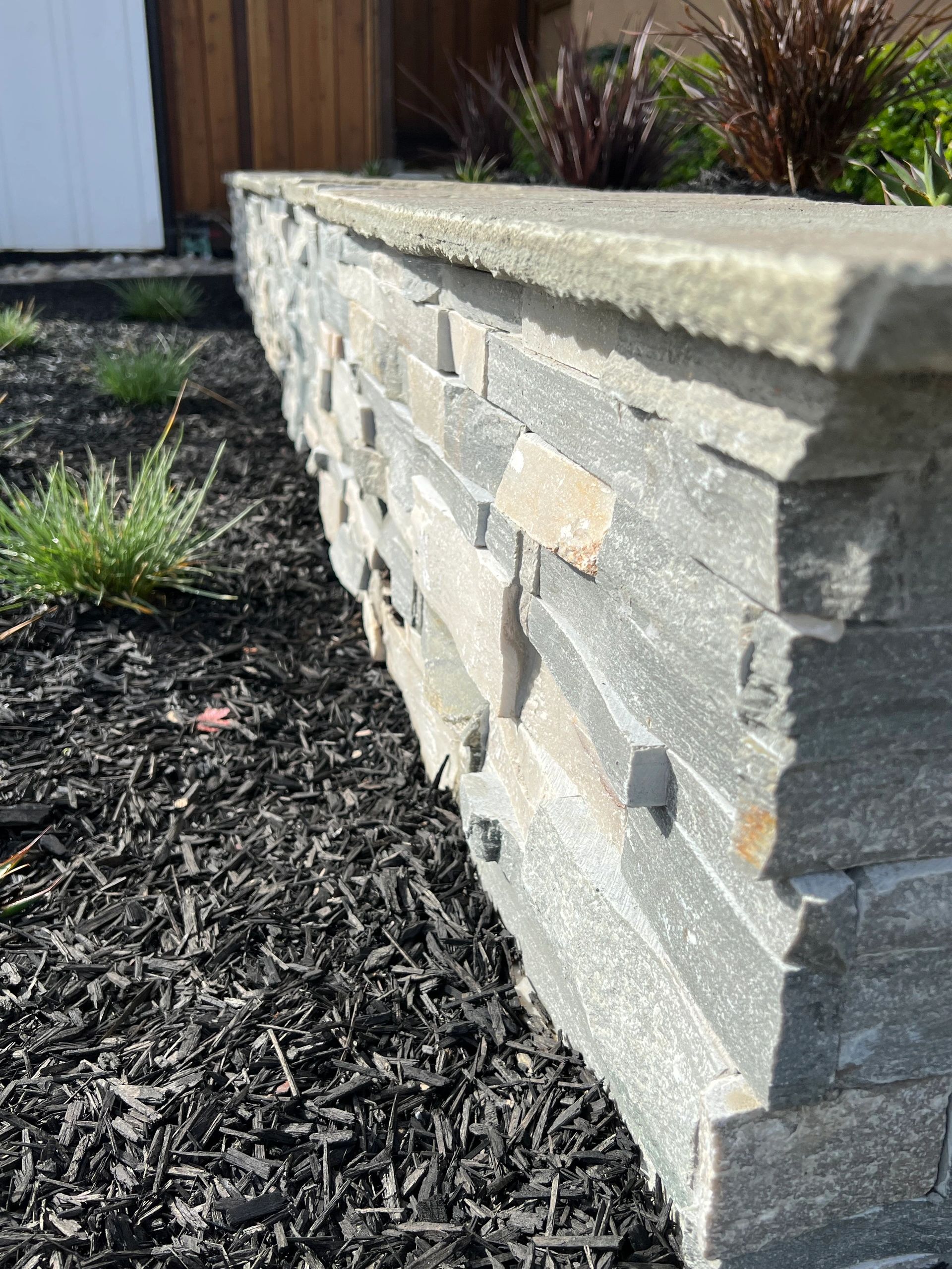 Textured stone wall in landscaped yard