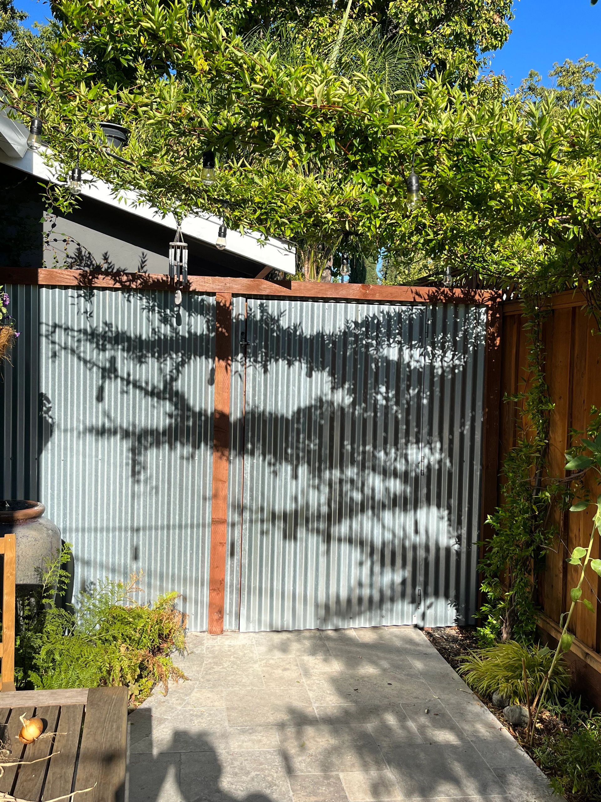 Sunlit garden path with metal gate