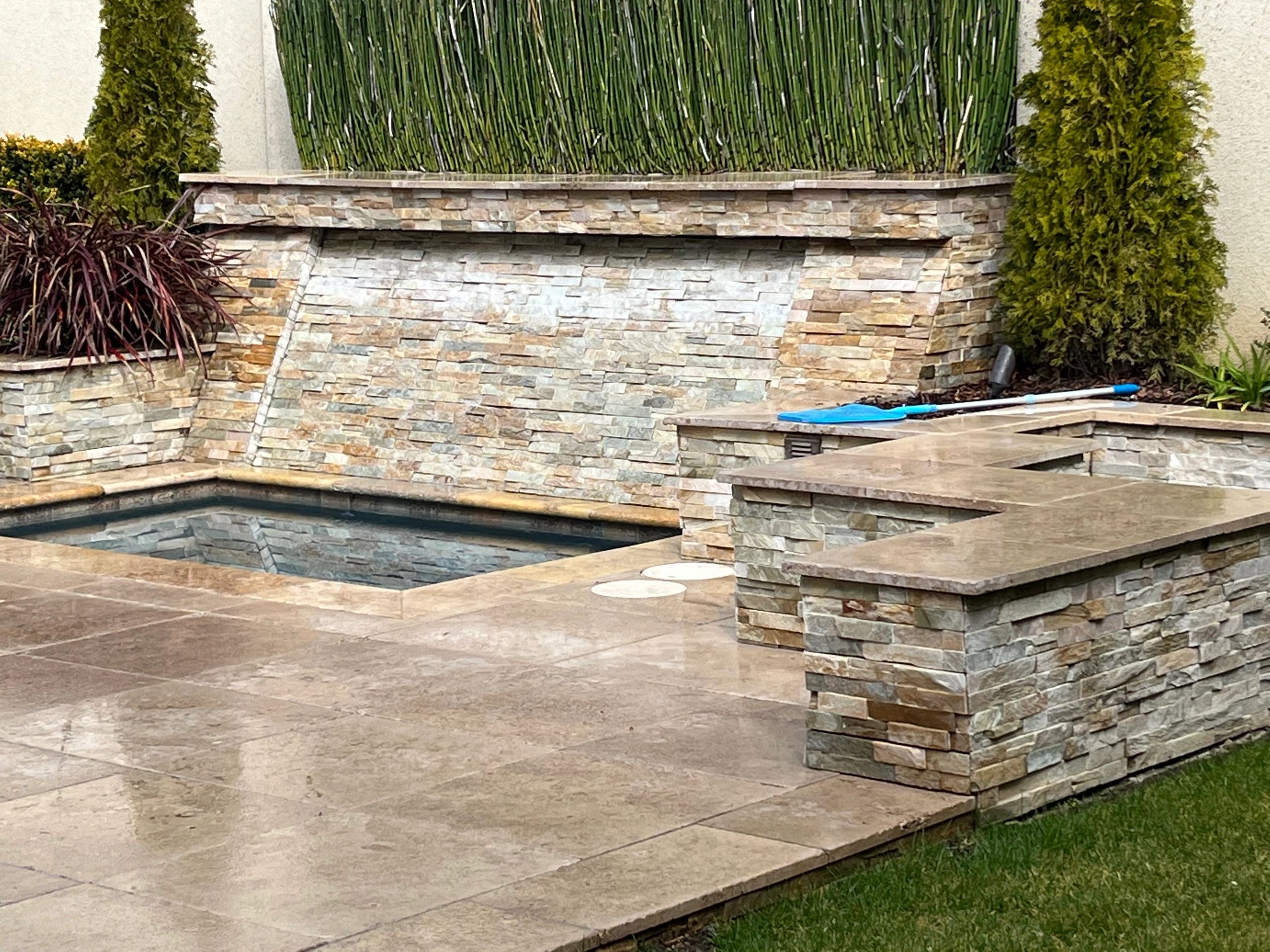 Modern garden with stone water fountain.