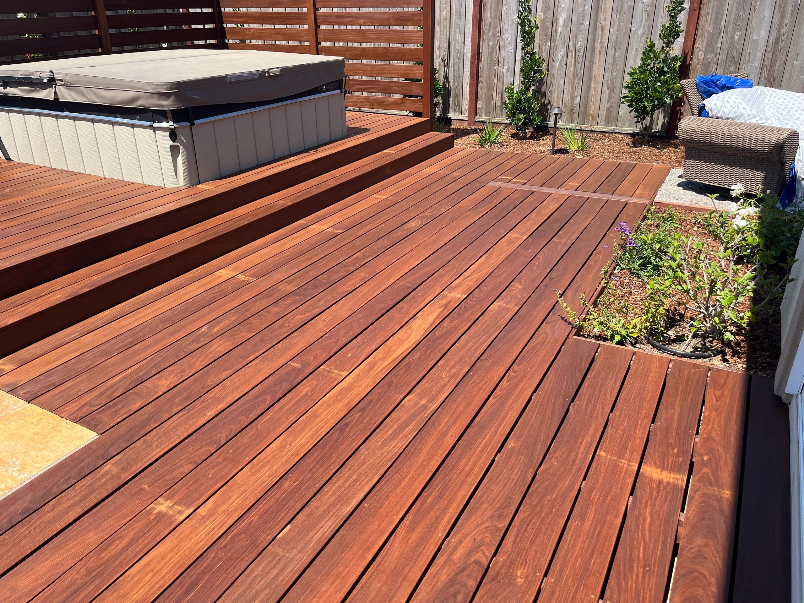 Sunlit wooden deck beside a hot tub