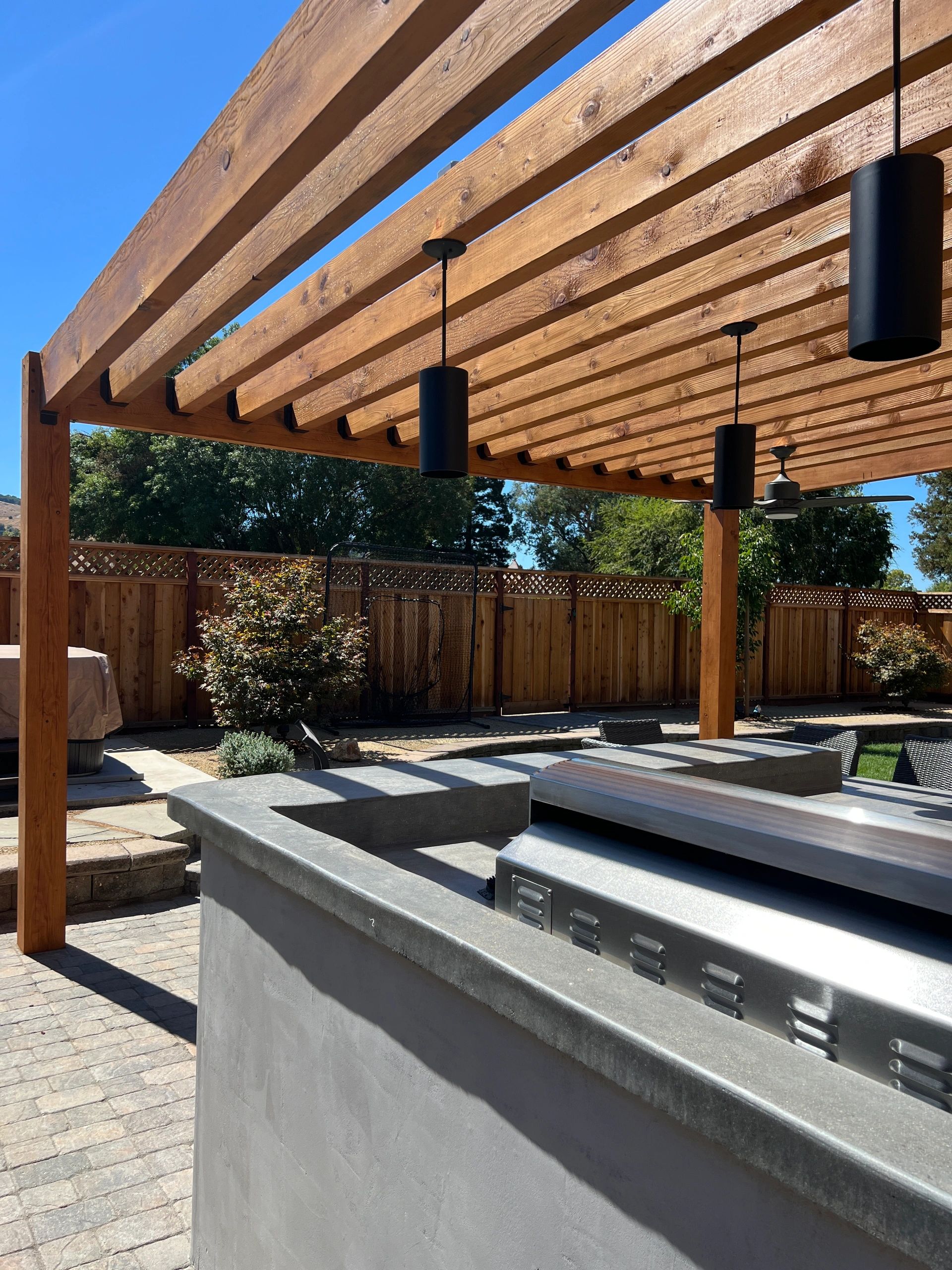 Wooden pergola over outdoor kitchen area