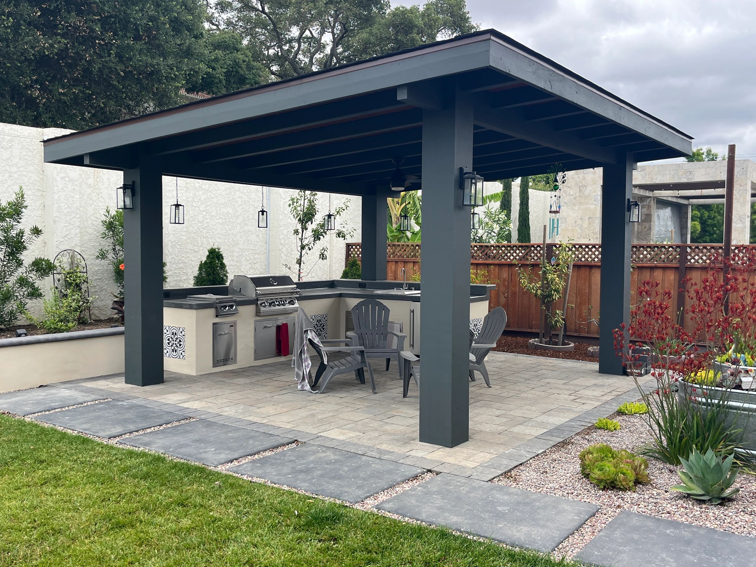 Backyard pergola with grill and chairs