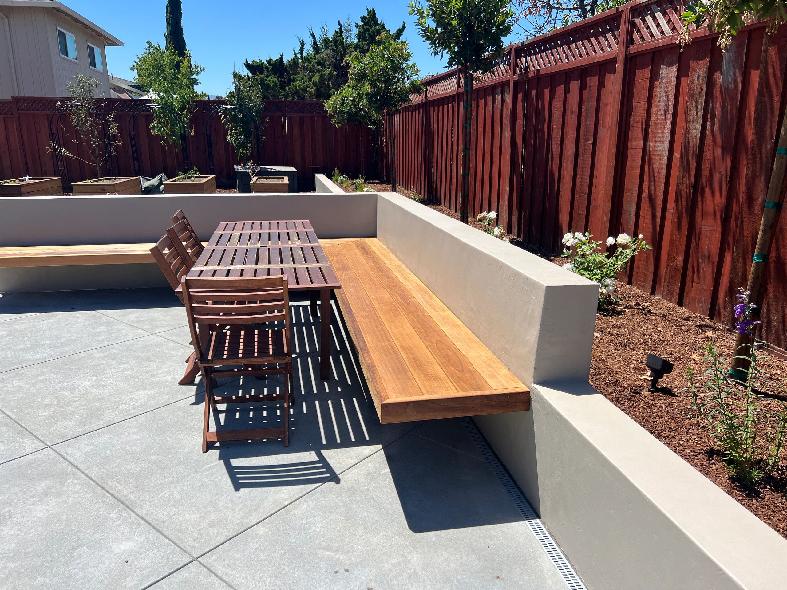 Modern patio with bench and dining table.
