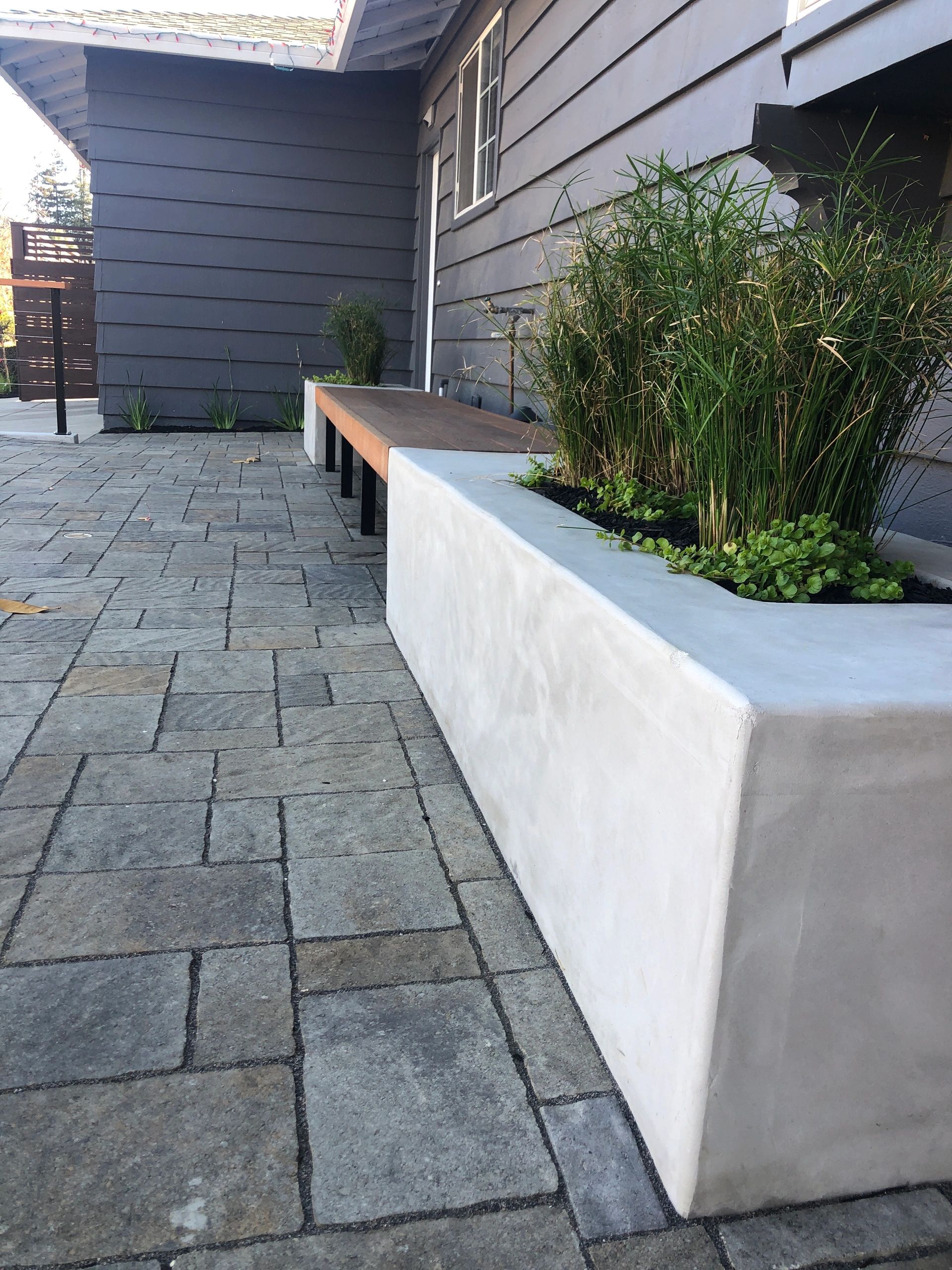 Outdoor area with pavers and greenery.