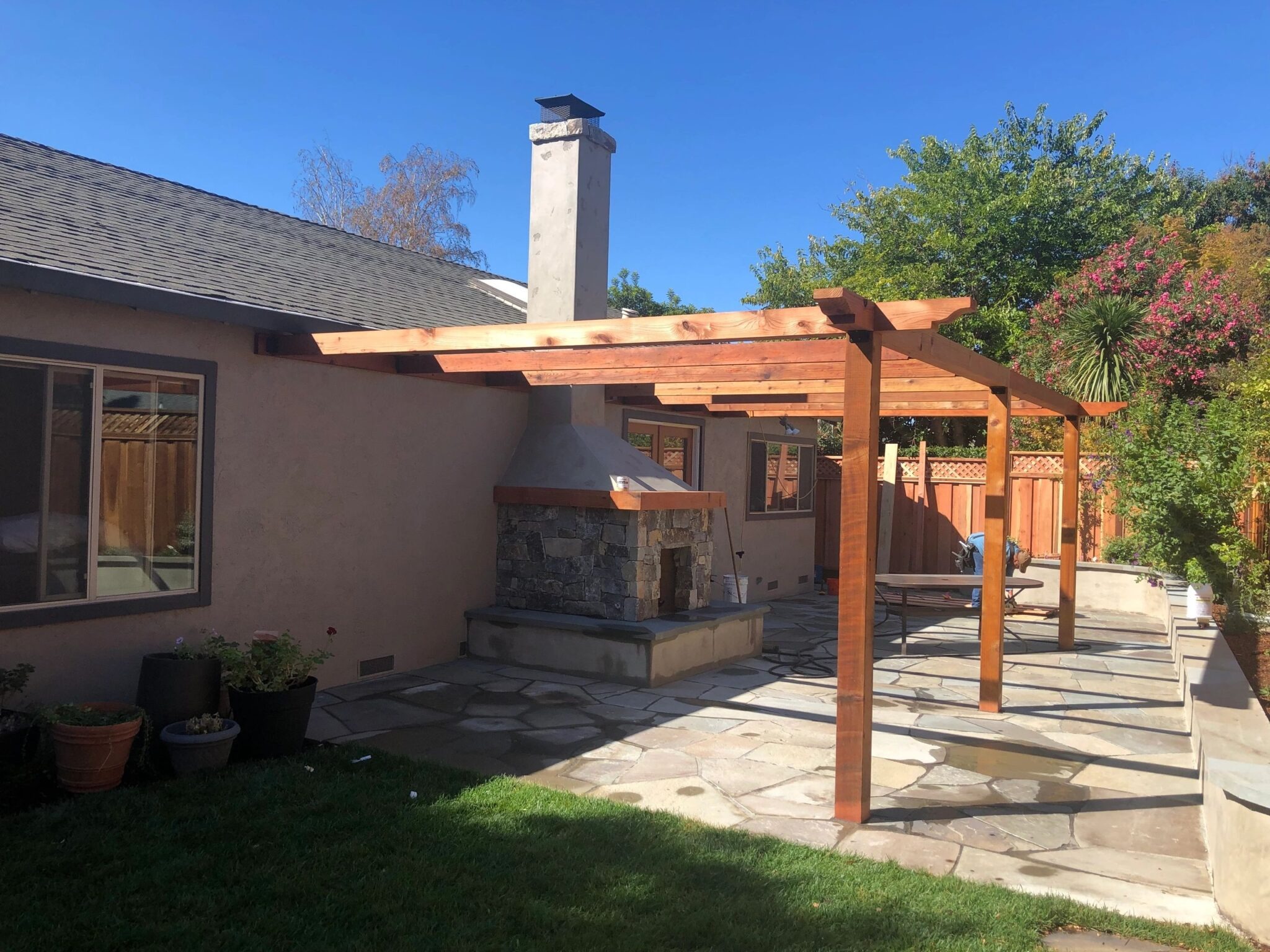 Sunny backyard with pergola and fireplace