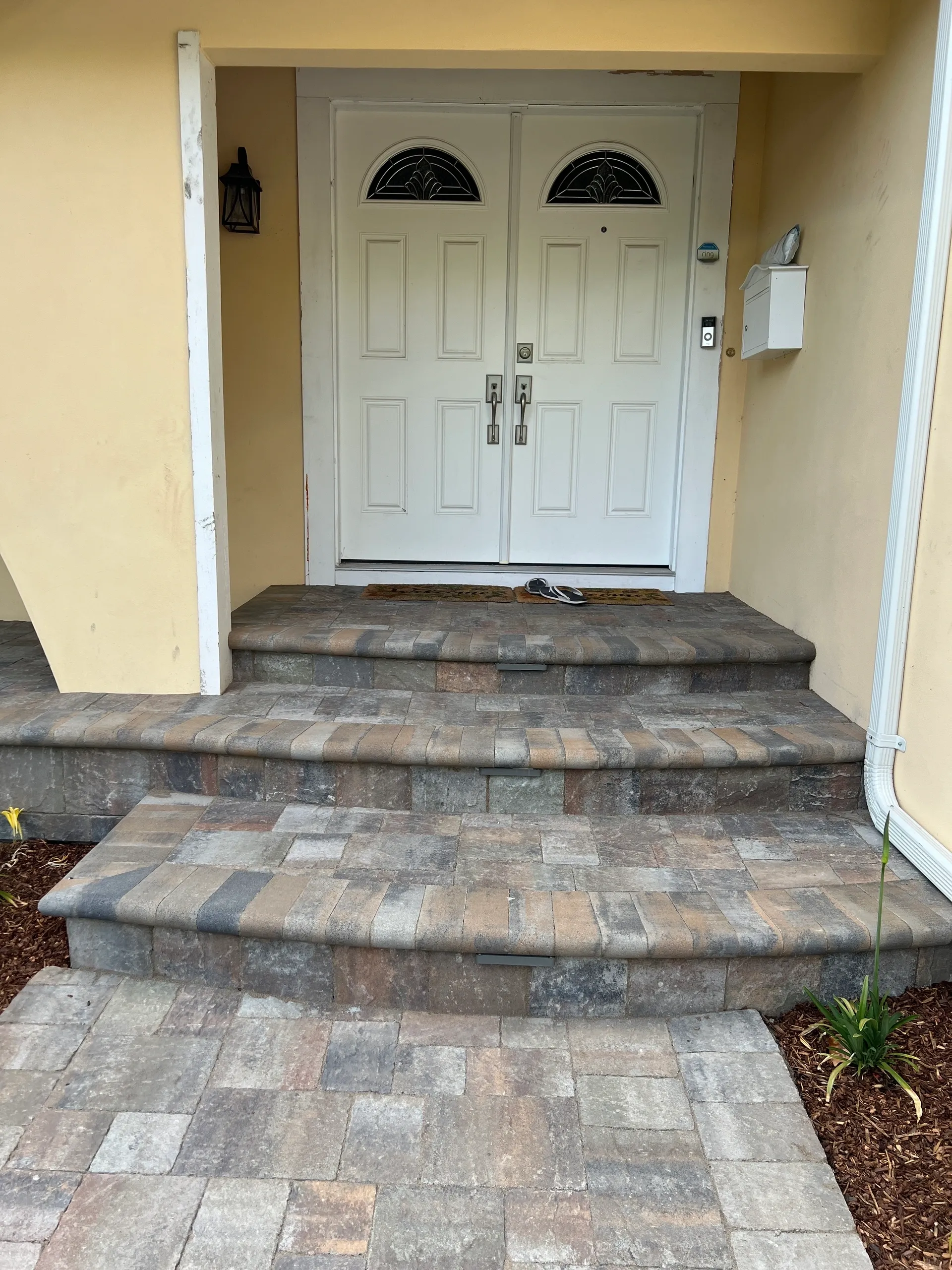 Front entrance with stone steps and plants.